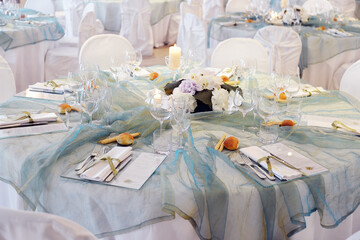 Detail of a table set in sea water color organza for a wedding banquet