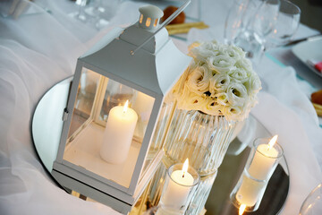 Detail of centerpiece with lantern flowers and candles for wedding banquet © antoniotruzzi