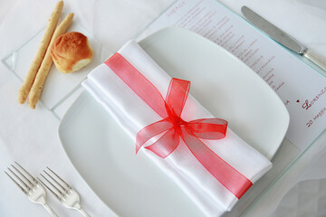Detail of napkin with red ribbon with menu for wedding banquet