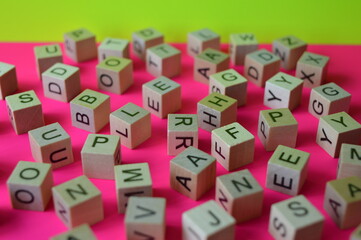 Wooden cubes with letters scattered randomly