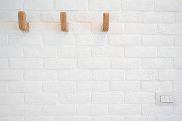 wooden hanger hook on white brick wall - Powered by Adobe