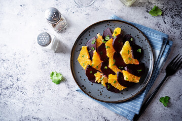 Beet orange cilantro salad with spicy olive oil vinegar sauce in a plate