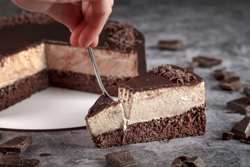 Classic mousse cappuccino cake on a gray background decorated with chocolate