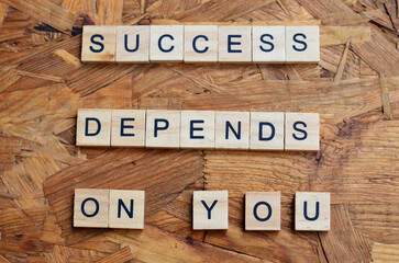 success depends on you text on wooden square, motivation and business quotes