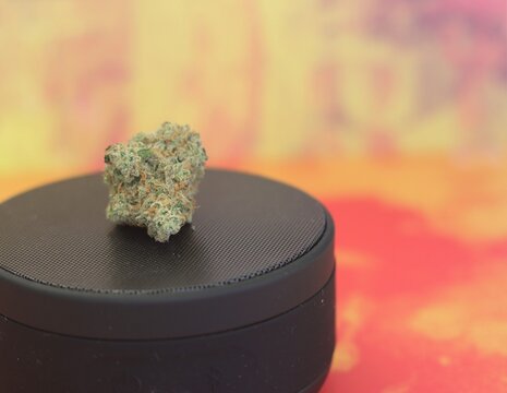 Cannabis bud on a speaker against a colorful background