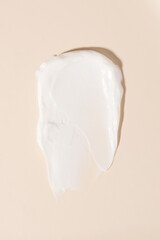 Cosmetic product creamy texture smudge on pastel beige background