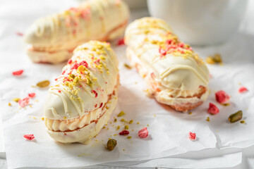 Homemade and cold eclairs with chocolate topping and pistachios.