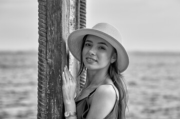 Portrait of a young beautiful girl in a hat. Black and white image - 520329312