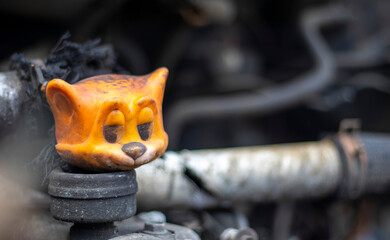 Broken car after a traffic accident. Auto insurance concept. Broken and damaged car. A toy in a burned-out car among spare parts and pipes.