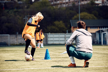Obraz premium Athletic woman during soccer practice on playing field.