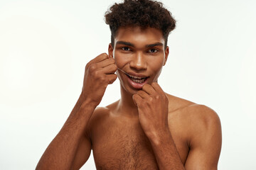 Cropped of black guy brush teeth with dental floss