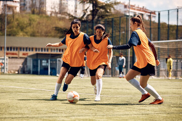 Athletic women play soccer on sports training at stadium.