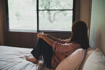 Sad asian woman suffering depression insomnia awake and sit alone on the bed in bedroom. sexual...