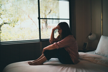 Sad asian woman suffering depression insomnia awake and sit alone on the bed in bedroom. sexual...