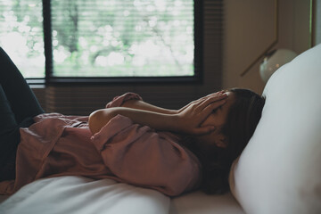Sad asian woman suffering depression insomnia awake and sit alone on the bed in bedroom. sexual harassment and violence against women, health concept