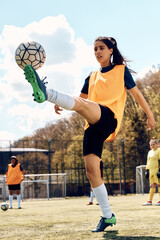 Soccer player kicking ball during sports training at stadium.