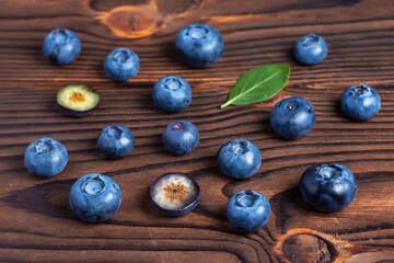 Fresh blueberries with leaves on wooden background