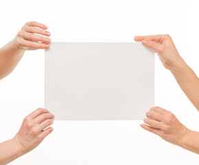 two pairs of female hands hands hold pull in different directions tear a blank sheet of paper document on a white background isolated