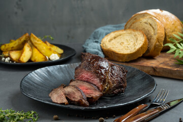 Baked meat on a dark background, food photography.