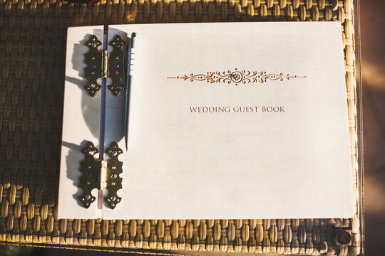 Wooden wedding guest book on a wicker table