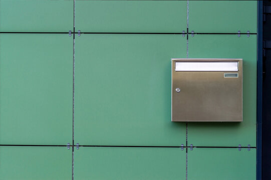 shiny metal mail box on the wall of a modern building