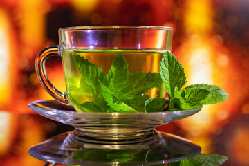 Cups of tea with fresh mint on multicolored background