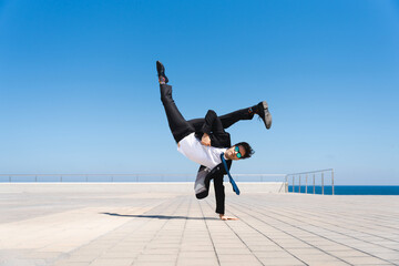 Flexible and cool businessman doing acrobatic trick - Powered by Adobe