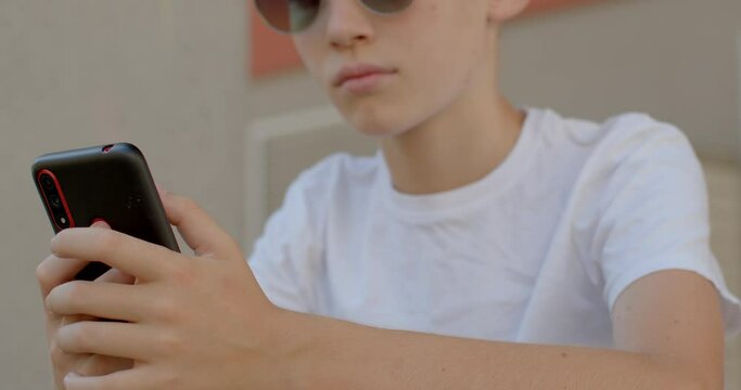 Portrait of boy with phone. The place of gadgets in the life of modern schoolchildren and students. E-learning with interest. Homework in the form of entertaining online tests. App for students.