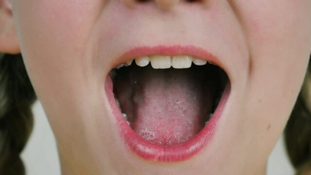the singing mouth of a beautiful girl. Close-up of baby lips and teeth