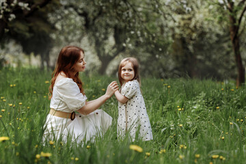 Mom and little daughter in the apple orchard