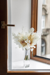 Delicate wedding bouquet on a wooden window sill
