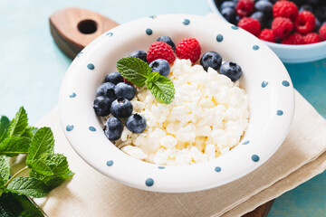 Homemade Cottage cheese with berries and mint. Cottage cheese in a bowl. Dairy products.