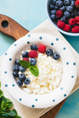 Homemade Cottage cheese with berries and mint. Cottage cheese in a bowl. Dairy products.