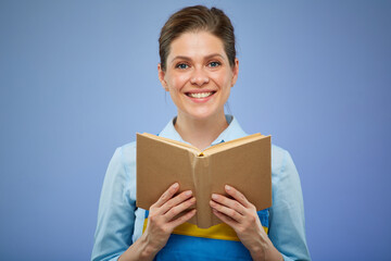 Obraz premium woman in blue overalls with open book. Isolated female portrait. vocational school concept.