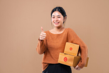 Happy Asian woman holding package parcel boxs isolated on background. Delivery courier and shippi