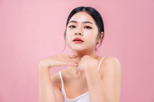 Beautiful Asian girl looking at camera isolated on pink background