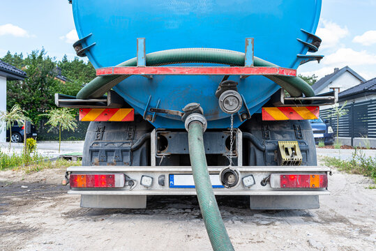 Long 4 inch PVC suction hose connected to the flange fitting on the trucks tank.