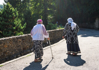 Two old women. Old women - one of the women moves with the help of a crutch.