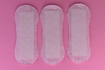 Women's sanitary pads on a pink background.
