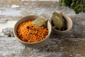 dry yellow lentils; raw legumes in a bowl; cooking ingredient; wooden background; horizontal format