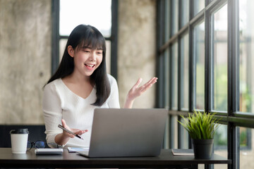 Young Asian businesswoman discussing video call on laptop computer in office