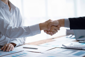 A group of Asian business people handshake to make a contract business agreement to start a new business.