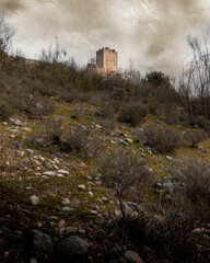 Landscape of the ruined castle of Otiñar in Jaen in the forest as a storm approaches.