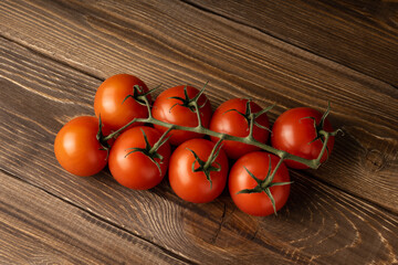 Red ripe tomatoes lie on an oak table.