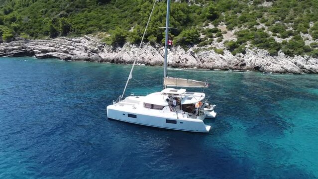 Flying around catamaran in a beautiful small bay of Croatia with final view at the sea