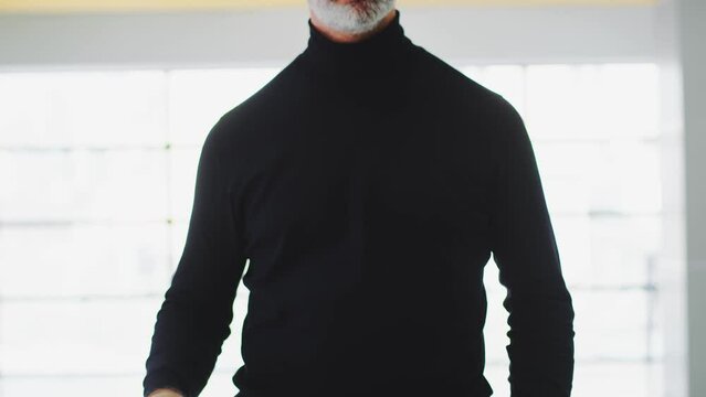 Male real estate agent raises his hands with a wooden house and keys with a keychain house, close-up. Concept of new housing. Housewarming