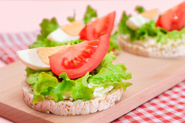 Rice Cake Sandwiches with Tomato, Lettuce and Egg on Wooden Cutting Board. Easy Breakfast. Diet Food. Quick and Healthy Sandwiches. Crispbread with Tasty Filling. Healthy Dietary Snack