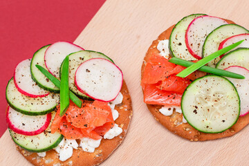 Crispy Cracker Sandwiches with Fresh Salmon, Cucumber, Radish, Cottage Cheese and Green Onions. Easy Breakfast. Quick and Healthy Sandwiches. Crispbread with Tasty Filling. Healthy Dietary Snack