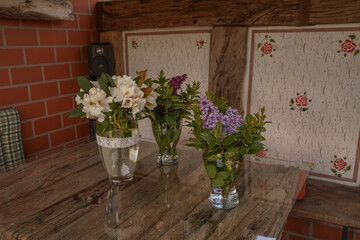 Fototapeta na wymiar Vases with wildflowers on a glass table