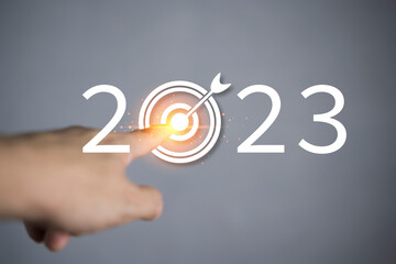 Finger about to press a car ignition button with the text 2023 start. Year two thousand